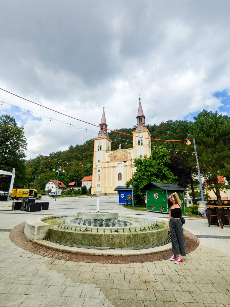 Tena na glavnom trgu u Pregradi ispred fontane i župne crkve Uznesenja Blažene Djevice Marije.