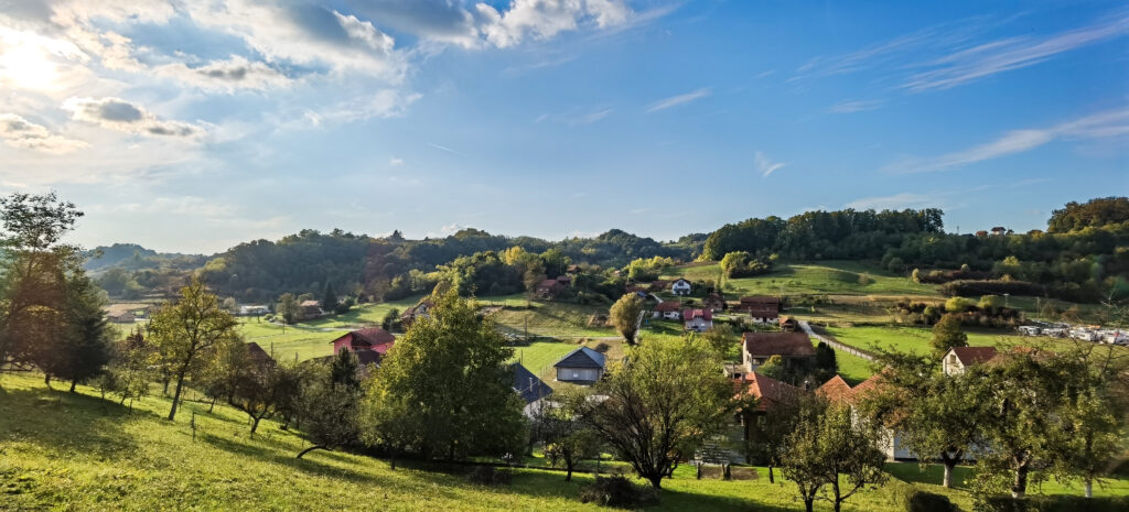 Pogled na zelene zagorske brege i raspoređene kuće u jesenskom pejzažu.