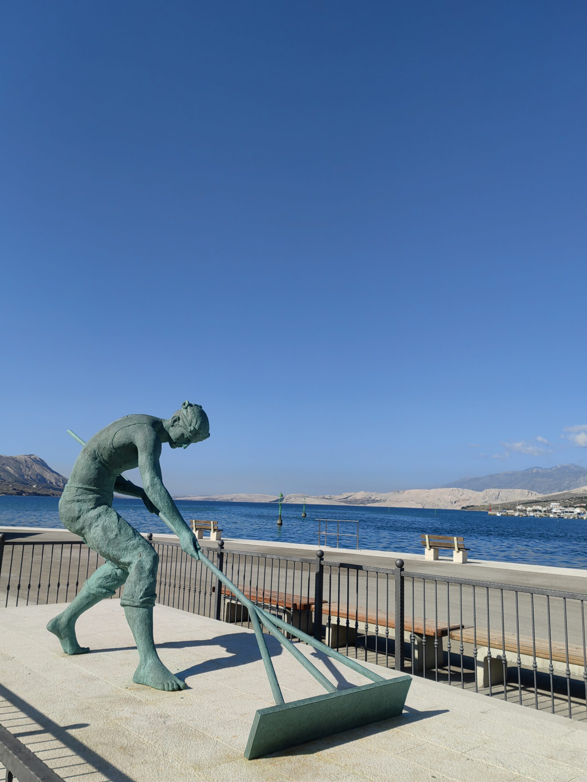 Statue of a traditional salt worker on the waterfront in Pag, Croatia